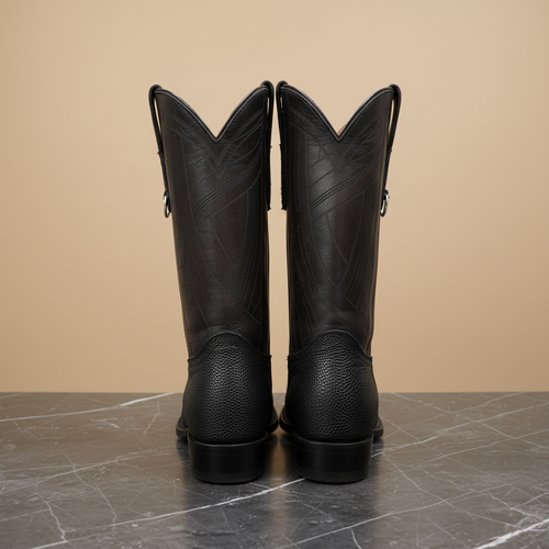 Botas vaqueras negras sobre mármol oscuro, vista trasera