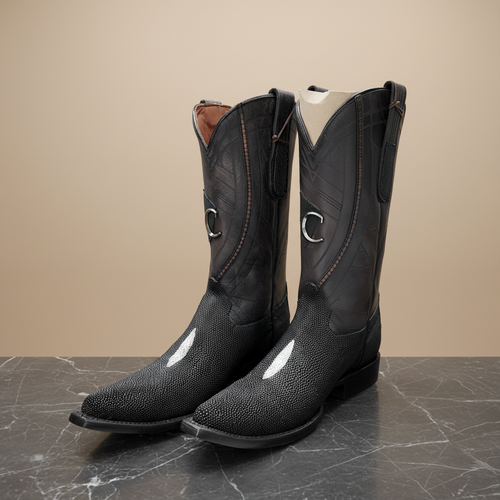 Botas vaqueras negras sobre mármol oscuro, vista frontal